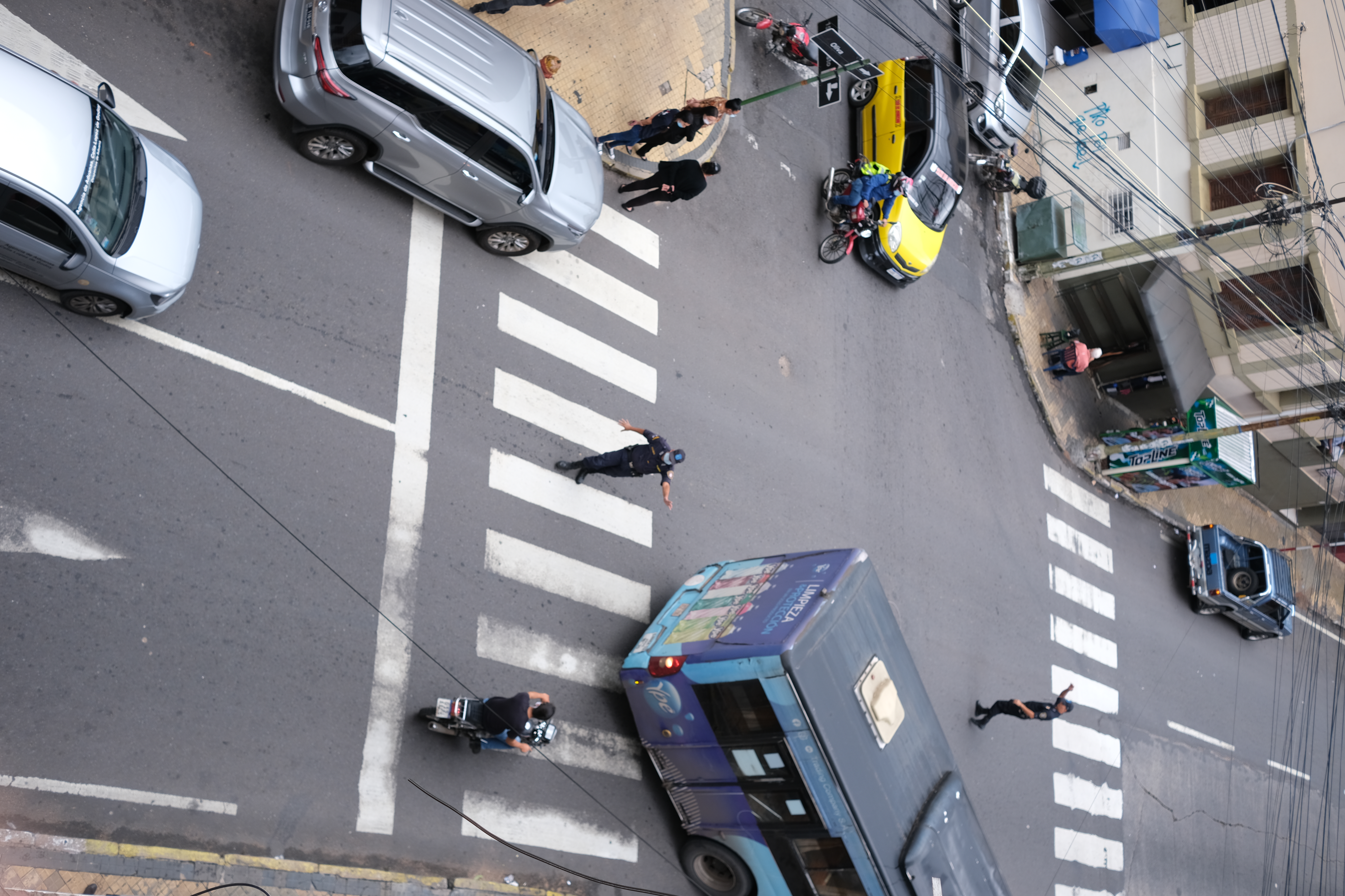 Taken from a balcony, shot of an intersection on which a police officer directs traffic